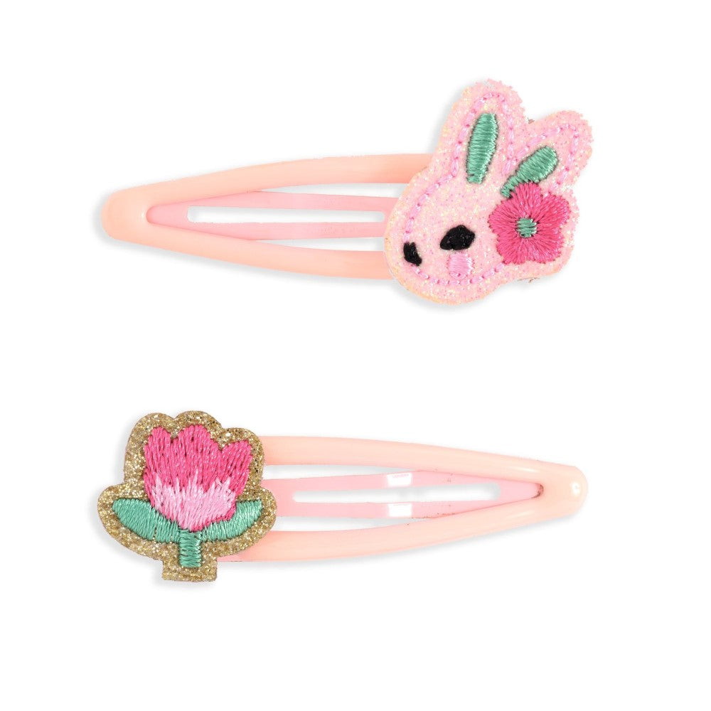 Two pink hair clips with floral designs on a white background