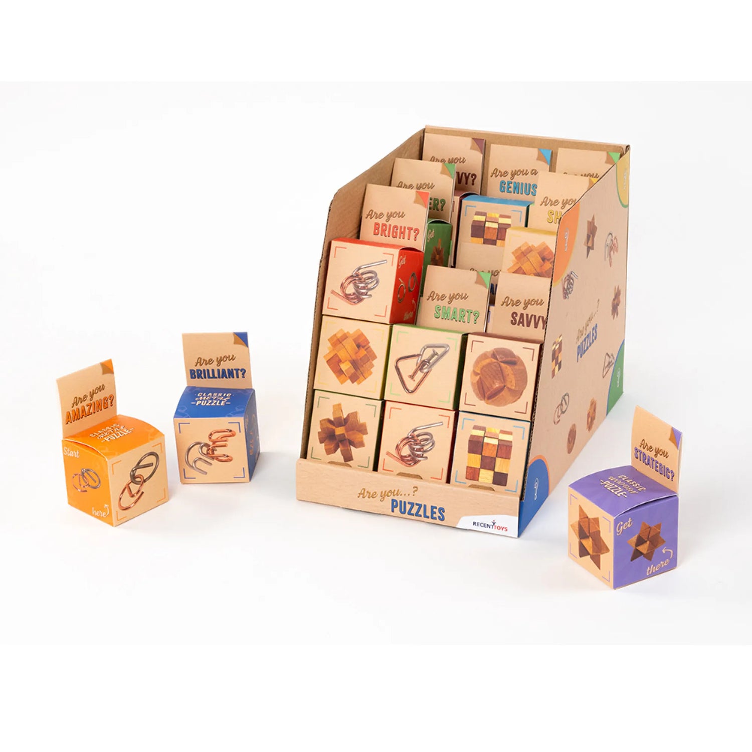 A display stand filled with small wooden puzzle boxes and several loose puzzle boxes arranged around it on a clean white background. The boxes are natural wood with printed words and simple puzzle illustrations.