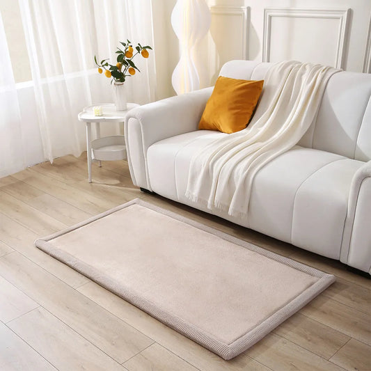 Beige rug on a wooden floor in a living room with a white sofa and yellow pillow.