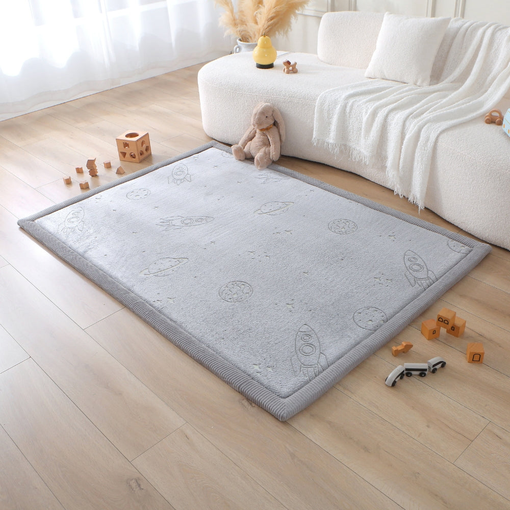 Gray play mat with space-themed design on a wooden floor in a living room.