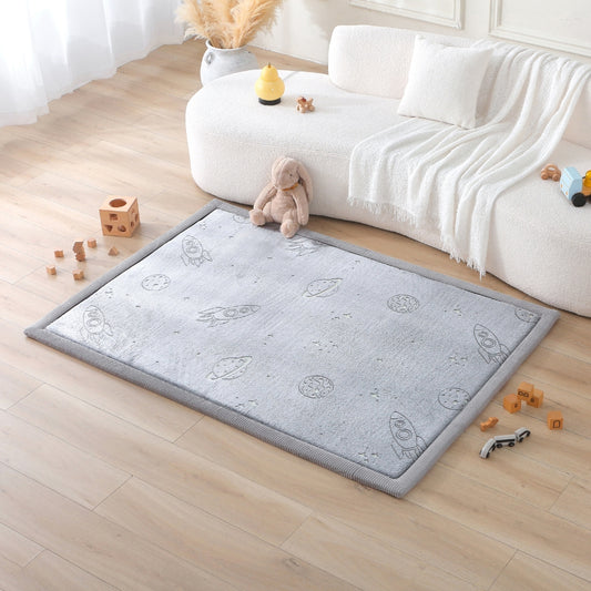 Gray play mat with space-themed design on a wooden floor in a living room.