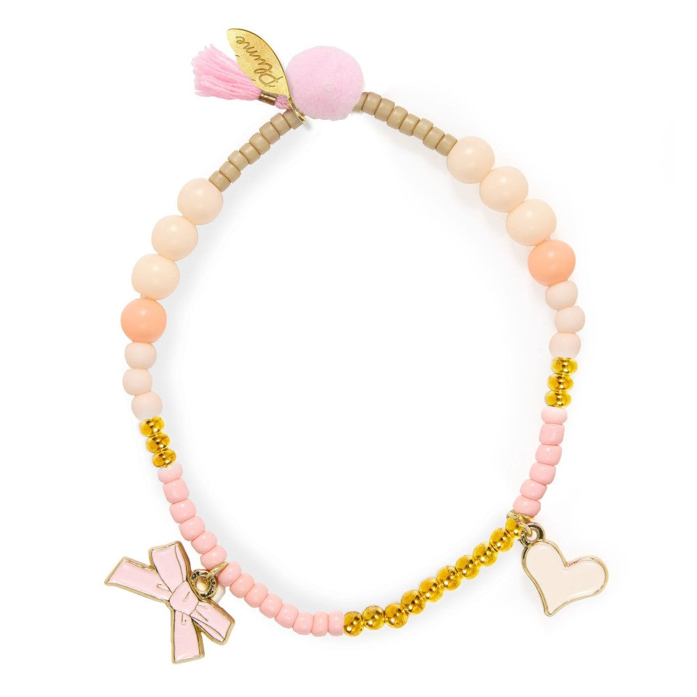 Beaded bracelet with pink tassel and charms on a white background