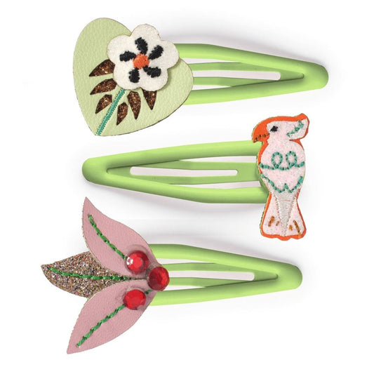 Two green hair clips with floral and bird designs on a white background