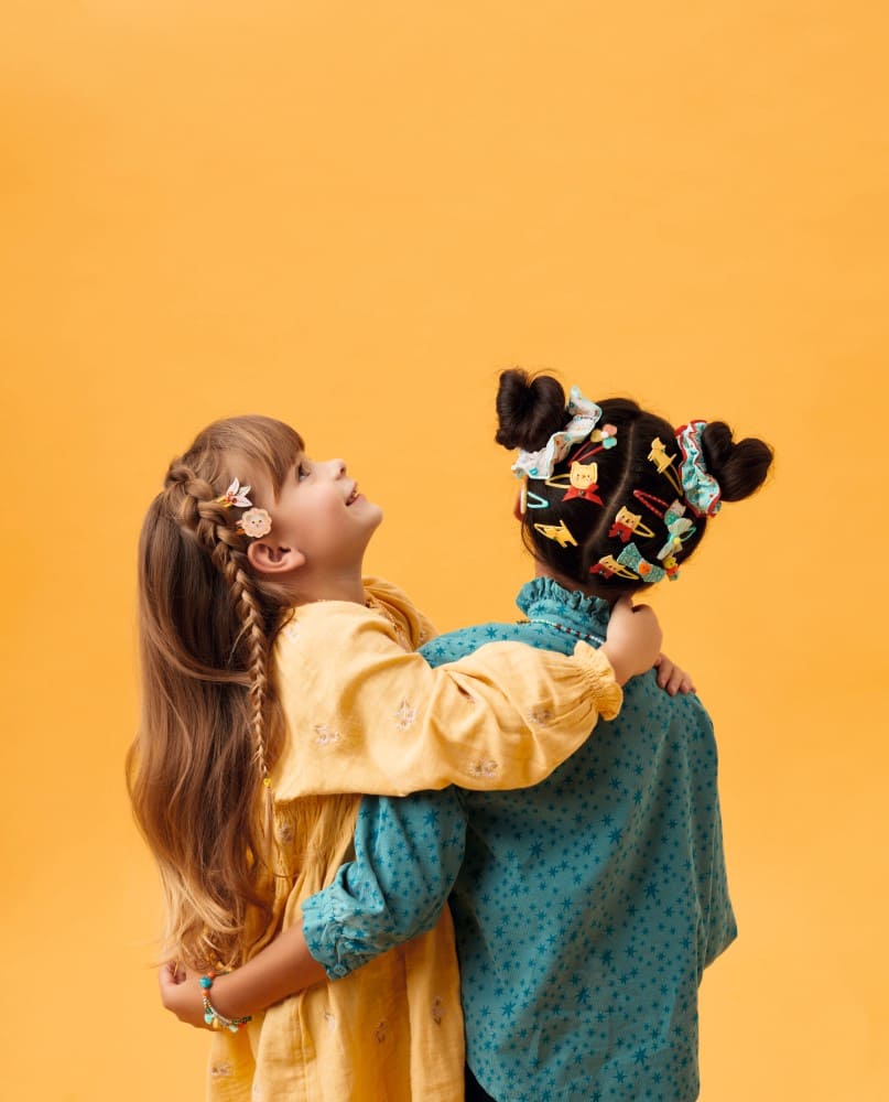 Two children with decorative hair against a yellow background