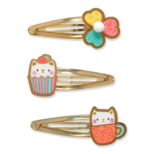 Three decorative hair clips with cat and cupcake designs on a white background