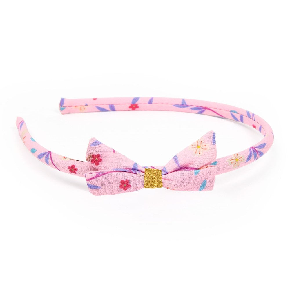 Pink floral headband with a bow on a white background