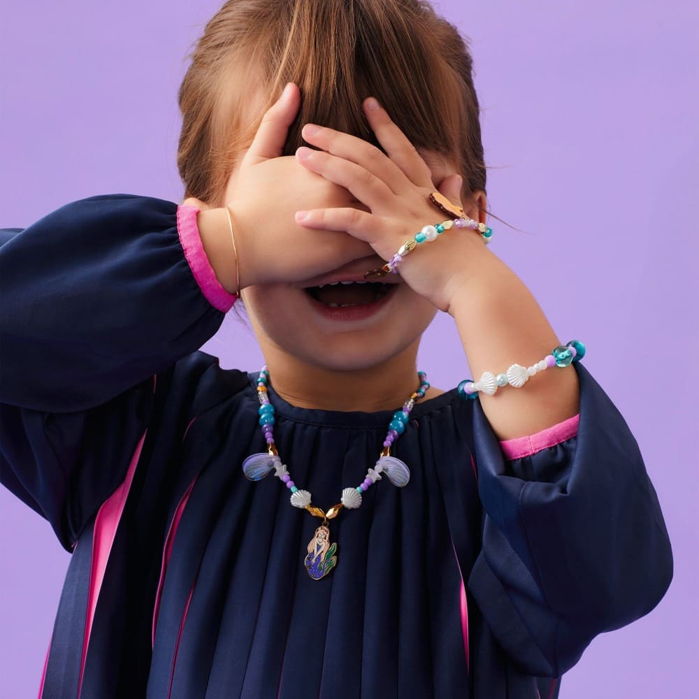 Child wearing jewelry with a purple background