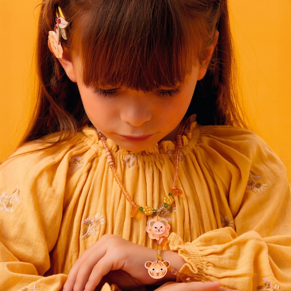 Child wearing a yellow dress with floral patterns against an orange background