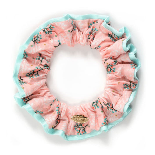 Pink floral scrunchie with a brand logo on a white background