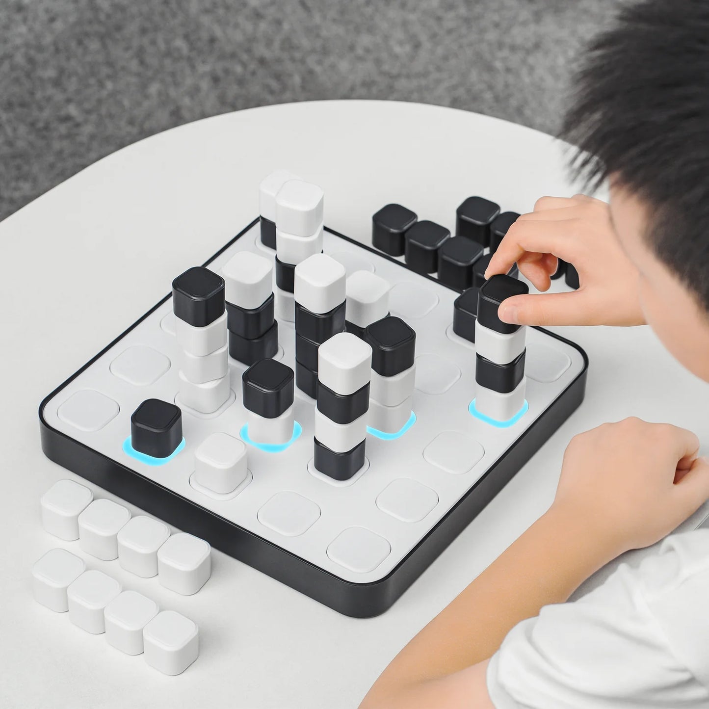 Child playing with a puzzle game on a white table