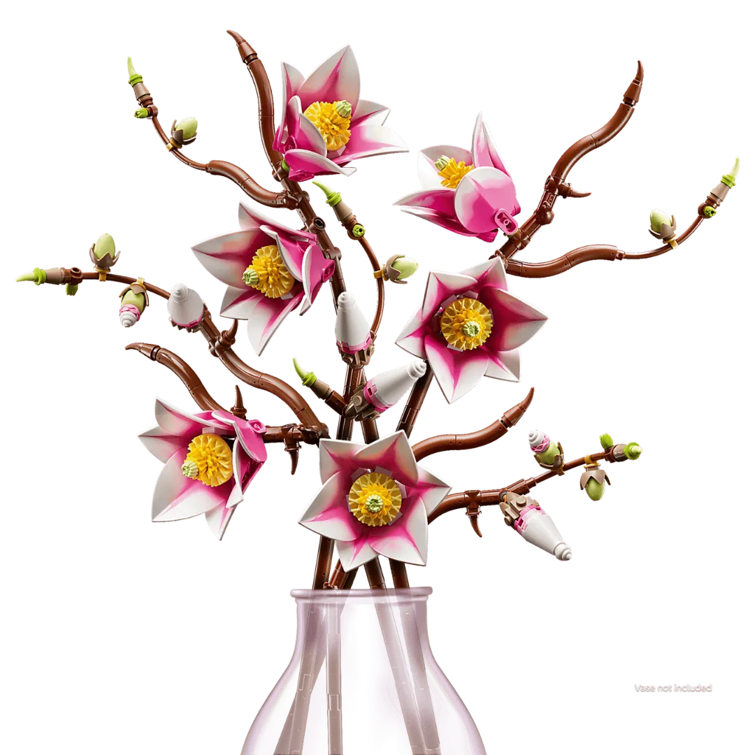 Artificial flower branch with pink flowers and yellow centers in a clear vase on a white background