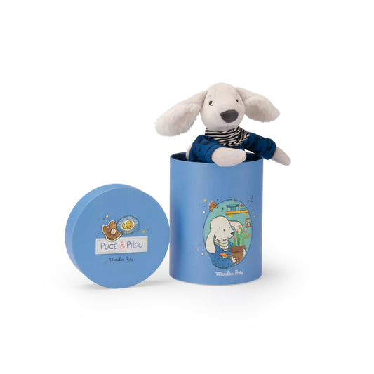 Stuffed dog toy in a blue cylindrical container with 'Puce & Pilou' branding on a white background.