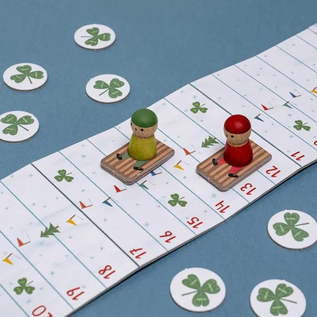 One Two Play Snow Race travel board game with two wooden sledding figures on a numbered snowy track with clover tokens