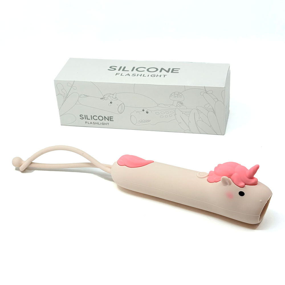 Silicone flashlight shaped like a cat with a pink nose and mouth, next to its packaging box on a white background.